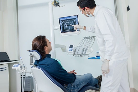 Profissional radiologista mostra para sua paciente uma radiografia digital.